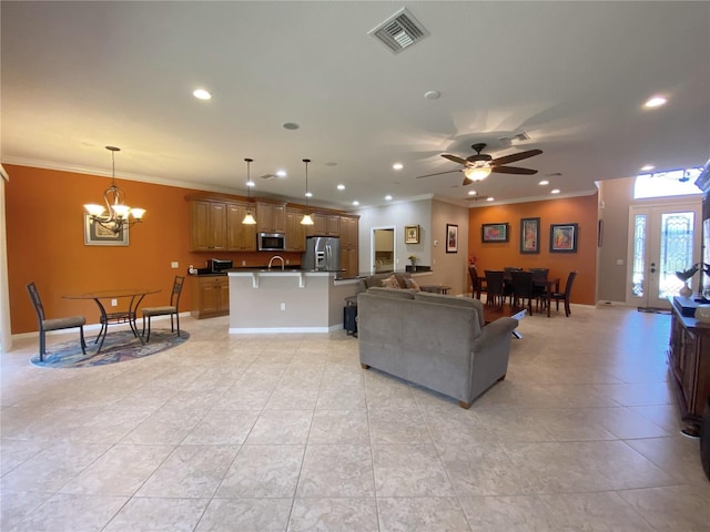 living room featuring ceiling fan with notable chandelier, sink, light tile patterned floors, and crown molding