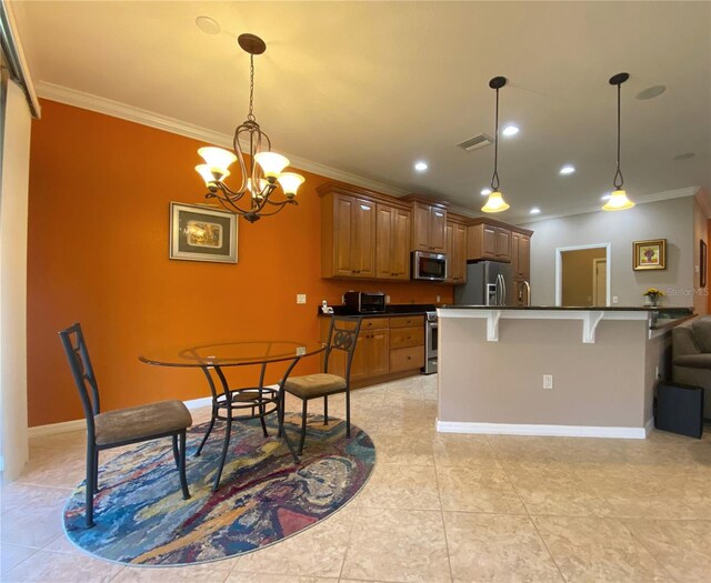 kitchen featuring ornamental molding, a chandelier, stainless steel appliances, and a breakfast bar