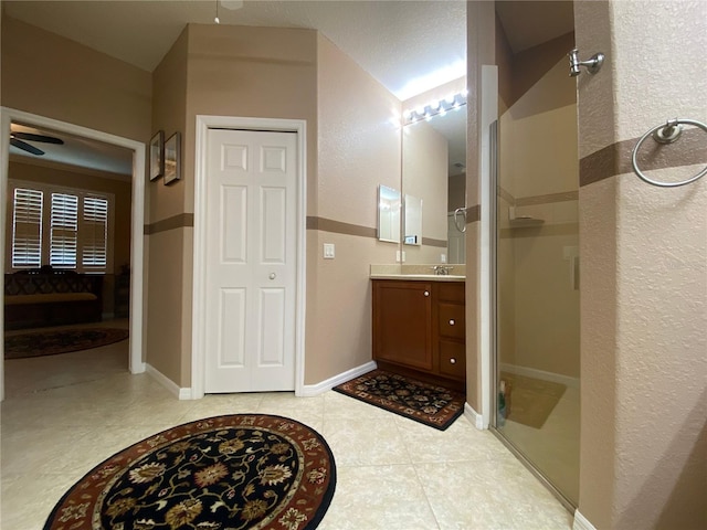 bathroom with tile patterned flooring, vanity, and ceiling fan