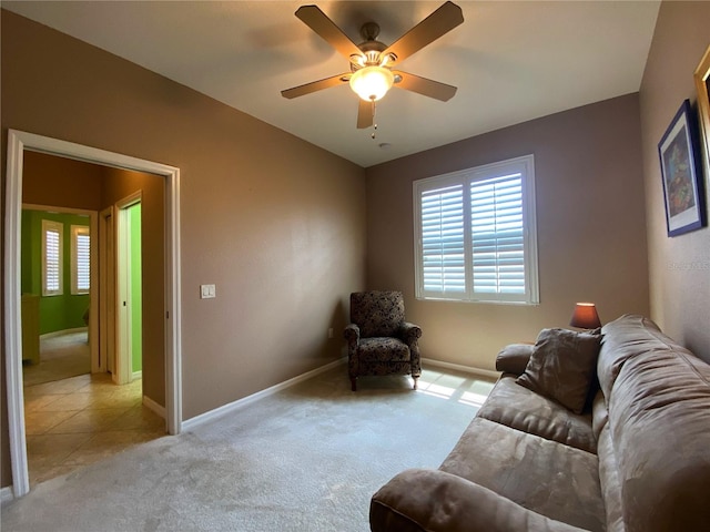 living area with light carpet and ceiling fan