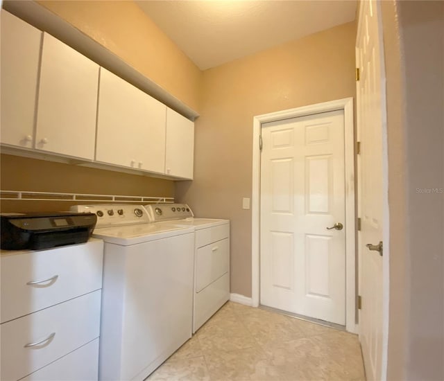 laundry area with washer and clothes dryer and cabinets