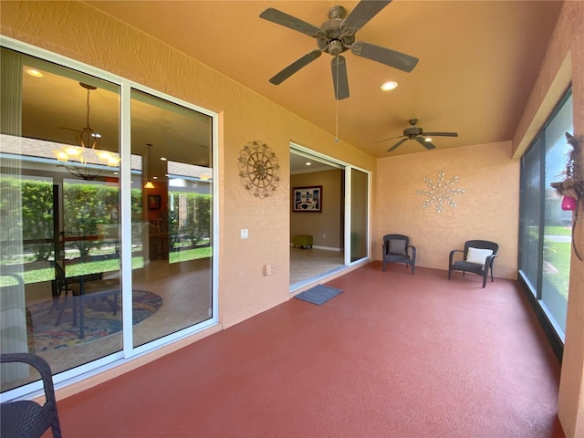 unfurnished sunroom featuring ceiling fan