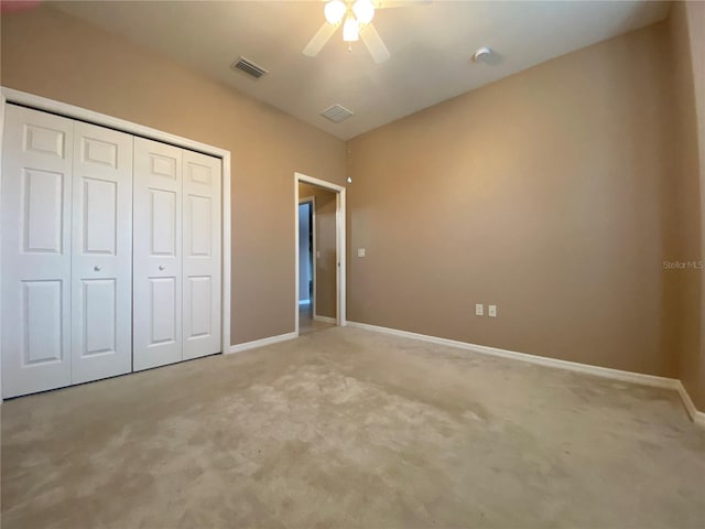 unfurnished bedroom featuring light carpet, a closet, and ceiling fan