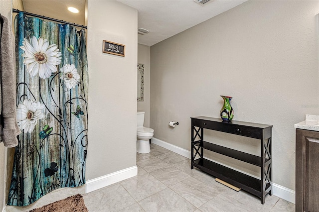 bathroom with tile flooring, toilet, and vanity