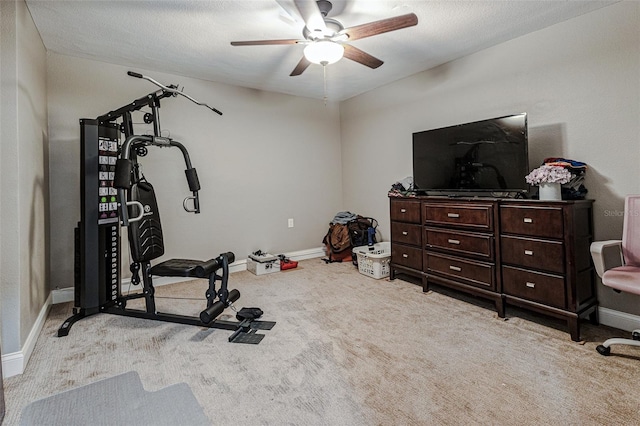 exercise area with light colored carpet, a textured ceiling, and ceiling fan