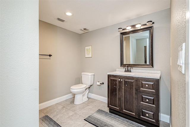 bathroom featuring tile flooring, toilet, and vanity