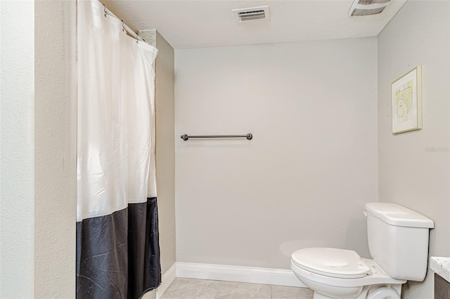 bathroom with toilet and tile floors