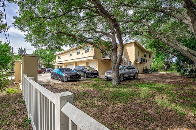 view of front of property with a wall mounted air conditioner and a garage