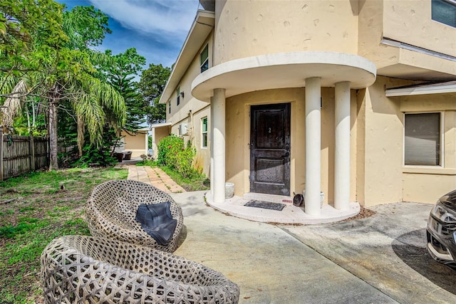 view of exterior entry with a patio area