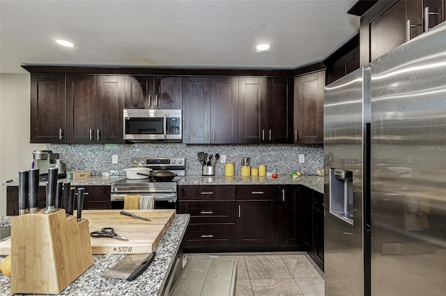 kitchen with tasteful backsplash, stainless steel appliances, and light stone countertops