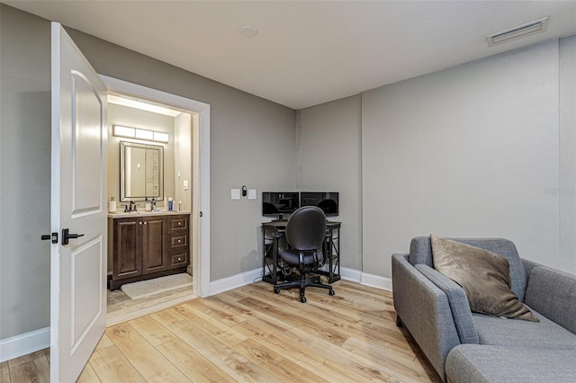 home office with sink and light wood-type flooring