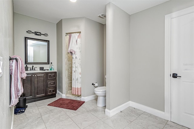 bathroom featuring tile flooring, toilet, and vanity
