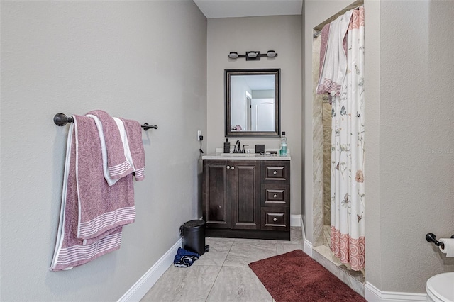 bathroom with toilet, vanity with extensive cabinet space, and tile floors