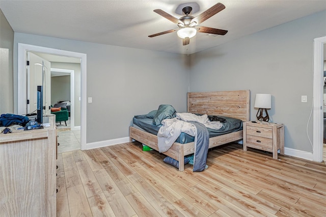 bedroom with light hardwood / wood-style floors and ceiling fan