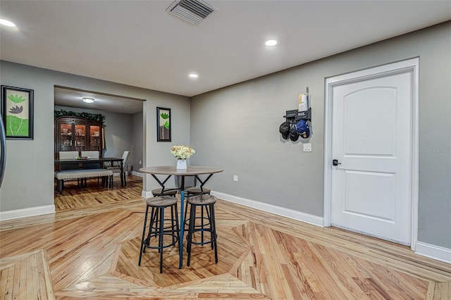 dining room with bar and light parquet floors