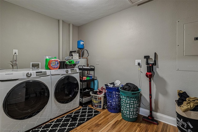 clothes washing area featuring hardwood / wood-style flooring, a textured ceiling, washer hookup, and washer and dryer