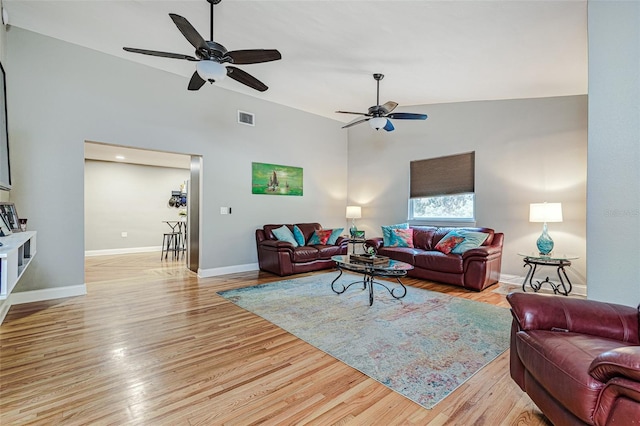 living room featuring ceiling fan, lofted ceiling, and light wood-type flooring