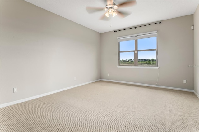 empty room featuring ceiling fan and light colored carpet