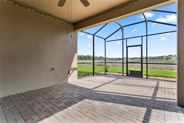 unfurnished sunroom with ceiling fan