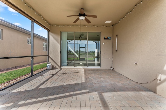 unfurnished sunroom with ceiling fan