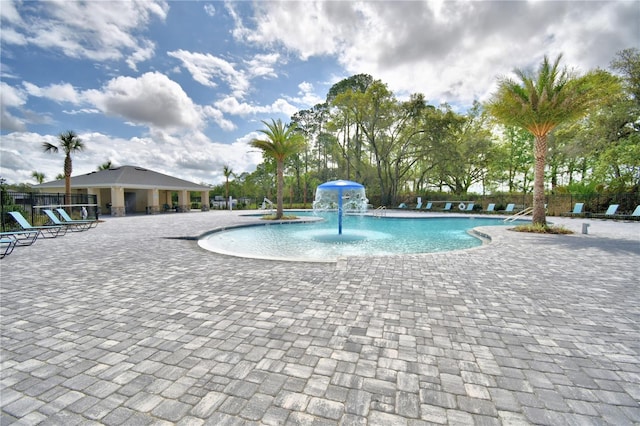 view of pool featuring pool water feature and a patio