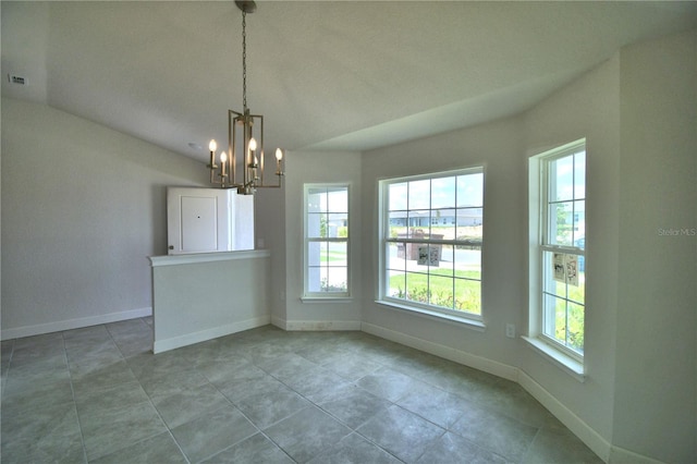 tiled empty room with a chandelier and vaulted ceiling