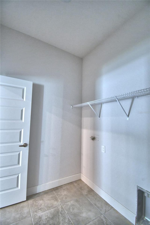 clothes washing area featuring light tile floors