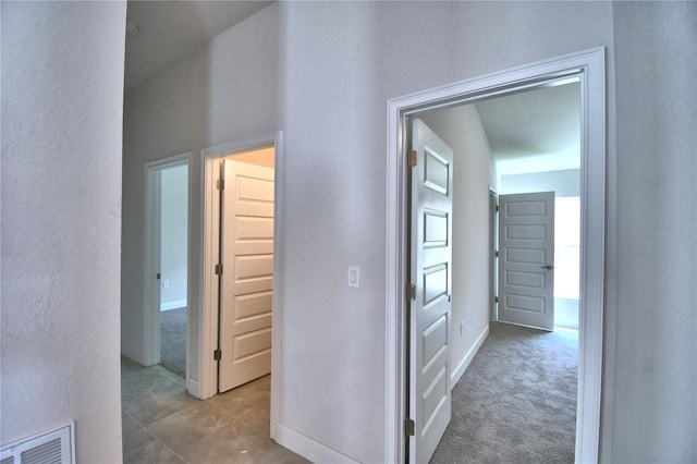 corridor featuring dark tile flooring