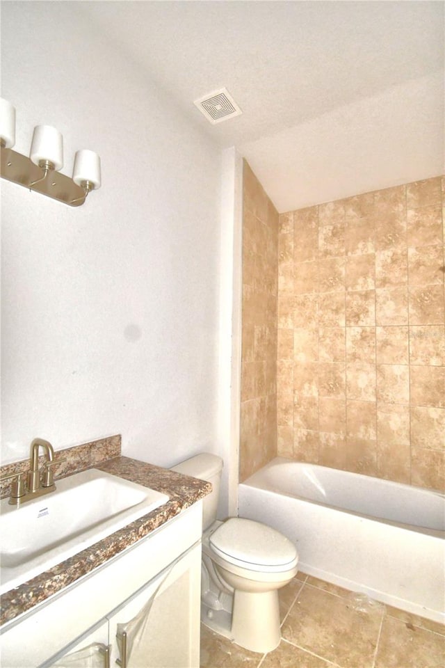 full bathroom with tile floors, toilet, vanity, and tiled shower / bath