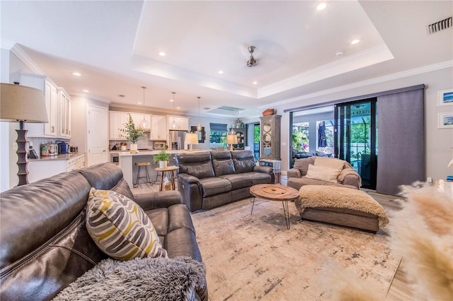 living room featuring crown molding and a tray ceiling