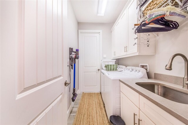 laundry area featuring cabinets, washer and dryer, and sink