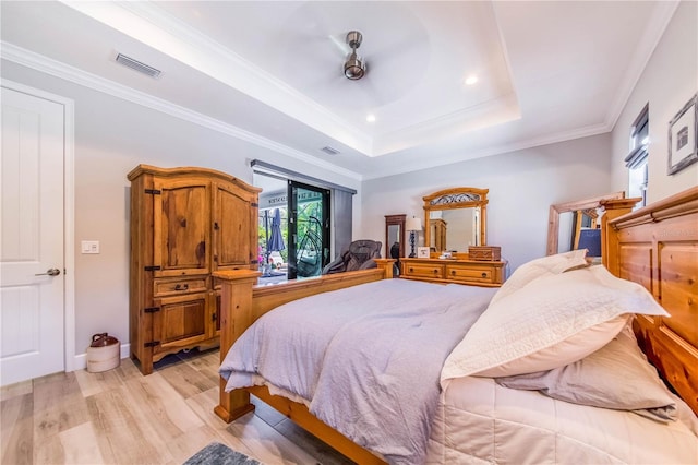 bedroom with a tray ceiling, ornamental molding, light hardwood / wood-style floors, and access to exterior