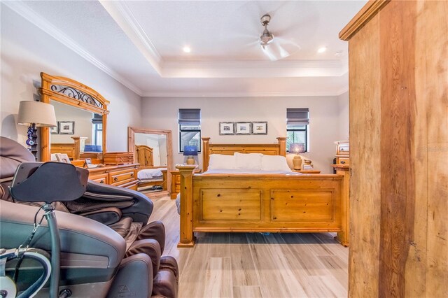 bedroom with a raised ceiling, light hardwood / wood-style floors, and crown molding