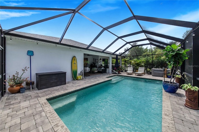 view of swimming pool with glass enclosure and a patio