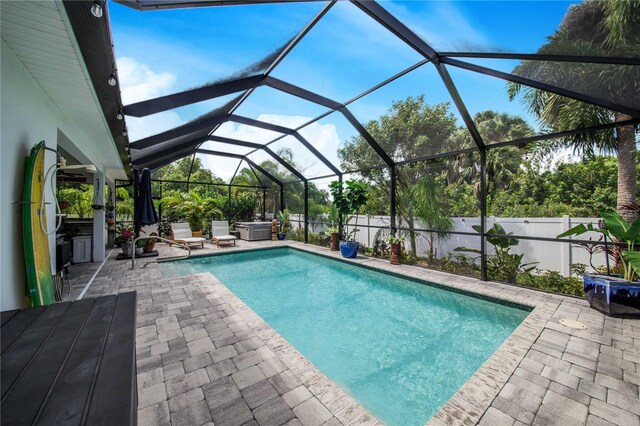 view of swimming pool with glass enclosure and a patio