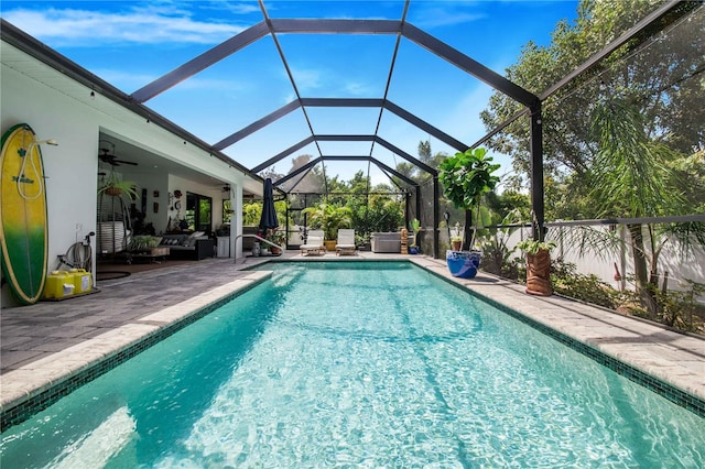 view of pool featuring an outdoor hangout area, glass enclosure, ceiling fan, and a patio