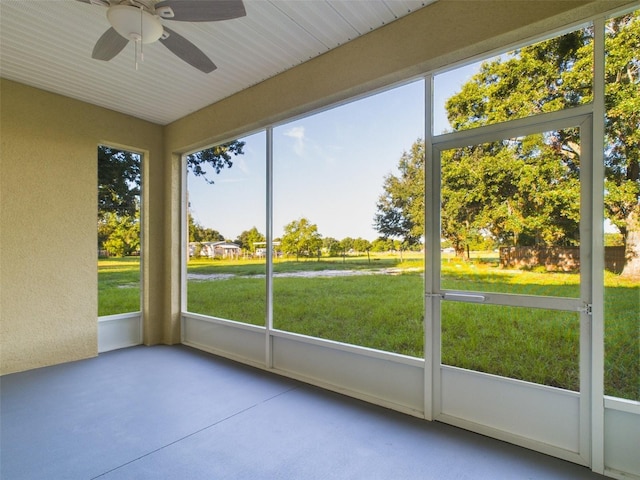 unfurnished sunroom with ceiling fan and a wealth of natural light