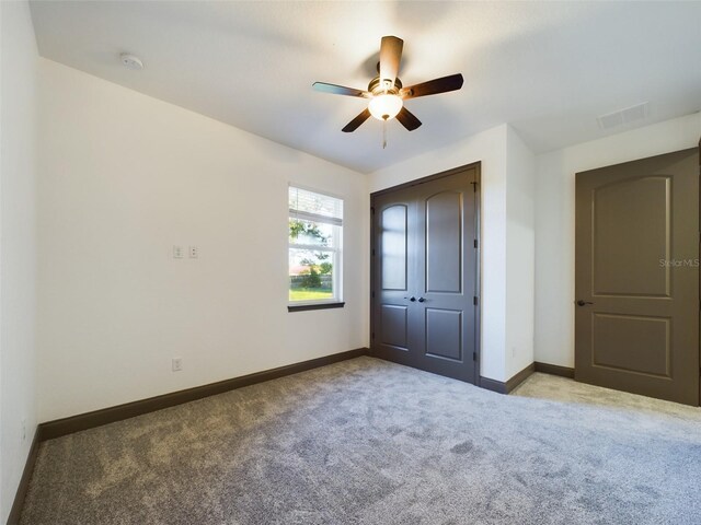 unfurnished bedroom featuring carpet flooring, ceiling fan, and a closet