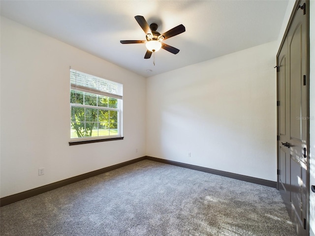 carpeted spare room featuring ceiling fan