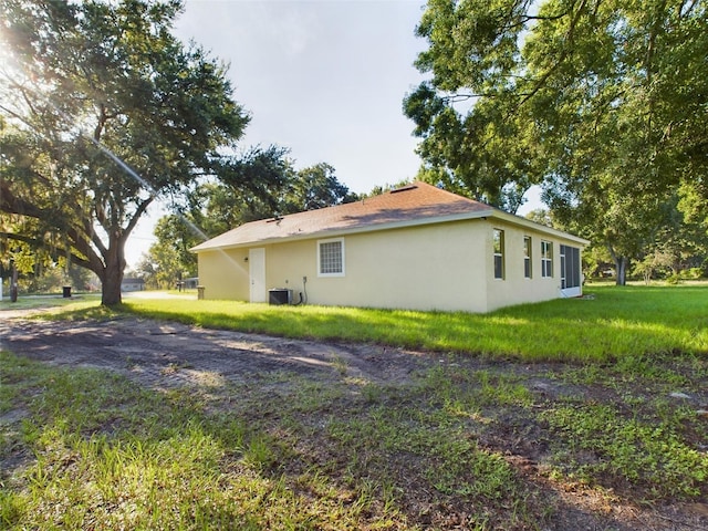 view of side of property featuring a yard and central air condition unit