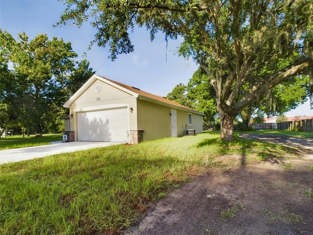 view of side of property featuring a garage and central AC unit