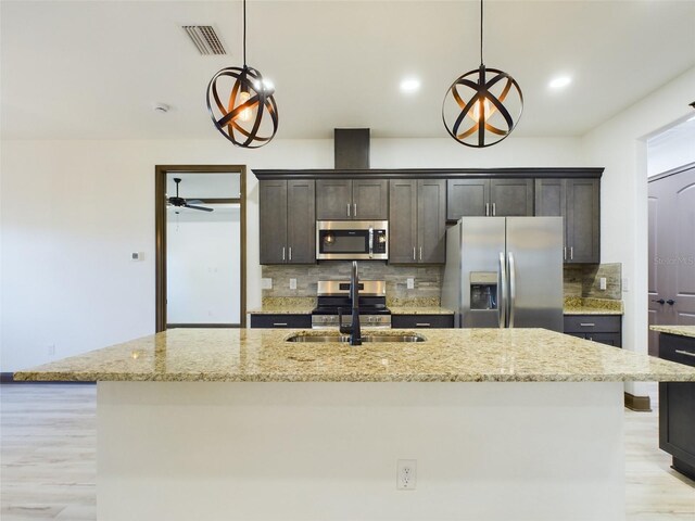 kitchen with pendant lighting, ceiling fan, stainless steel appliances, and sink