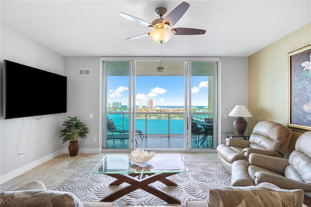 living room with a water view and ceiling fan