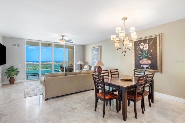 tiled dining room with ceiling fan with notable chandelier and a wall of windows