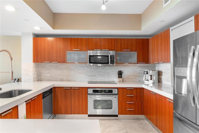 kitchen featuring appliances with stainless steel finishes, tasteful backsplash, sink, and light tile flooring