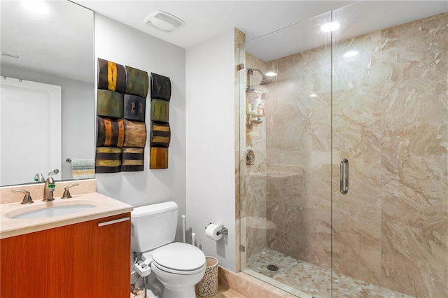 bathroom with toilet, an enclosed shower, and vanity with extensive cabinet space