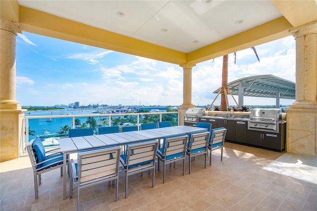 view of patio / terrace featuring area for grilling, grilling area, a water view, and a balcony