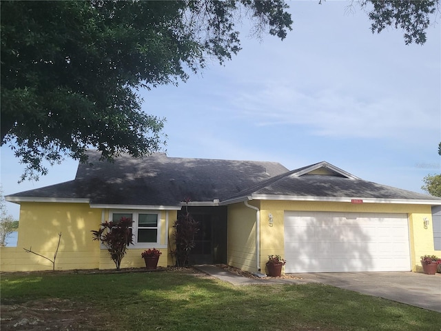 single story home featuring a garage and a front lawn