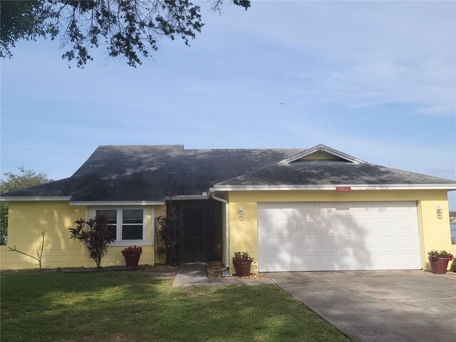 ranch-style house featuring a garage and a front lawn