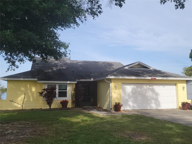 ranch-style home with a garage and a front lawn